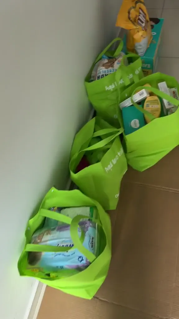 Bolsas verdes con productos preparadas en un espacio interior.